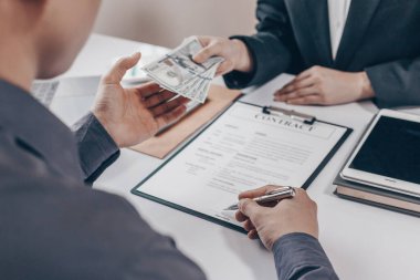 İşadamları, yasadışı arazi ve gayrimenkul, iş dolandırıcılığı ve sosyal adaletsizlik, yolsuzluk ve rüşvet kavramını satın almak için sözleşmeler imzalayan çalışanlara dolar dağıtıyor.