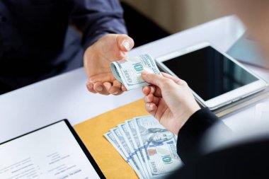 İşadamları, yasadışı arazi ve gayrimenkul, iş dolandırıcılığı ve sosyal adaletsizlik, yolsuzluk ve rüşvet kavramını satın almak için sözleşmeler imzalayan çalışanlara dolar dağıtıyor.
