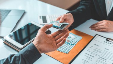 İşadamları, yasadışı arazi ve gayrimenkul, iş dolandırıcılığı ve sosyal adaletsizlik, yolsuzluk ve rüşvet kavramını satın almak için sözleşmeler imzalayan çalışanlara dolar dağıtıyor.