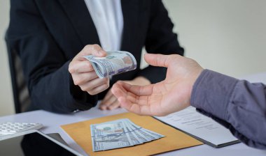 İşadamları, yasadışı arazi ve gayrimenkul, iş dolandırıcılığı ve sosyal adaletsizlik, yolsuzluk ve rüşvet kavramını satın almak için sözleşmeler imzalayan çalışanlara dolar dağıtıyor.