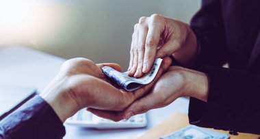 İşadamları, yasadışı arazi ve gayrimenkul, iş dolandırıcılığı ve sosyal adaletsizlik, yolsuzluk ve rüşvet kavramını satın almak için sözleşmeler imzalayan çalışanlara dolar dağıtıyor.