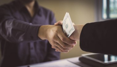 Şeytani bir plan için tebrik eden işadamları, yasadışı arazi ve gayrimenkul, yolsuzluk ve rüşvet konsepti satın almak için sözleşme imzalayan çalışanlara rüşvet olarak dolar veriyorlar.,