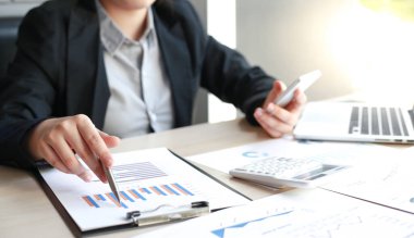 Finans işadamları şirketin kâr ve büyüme, piyasa araştırma raporları ve gelir istatistikleri, Finansal ve Muhasebe kavramı yaratma performansının grafiğini analiz ediyor.