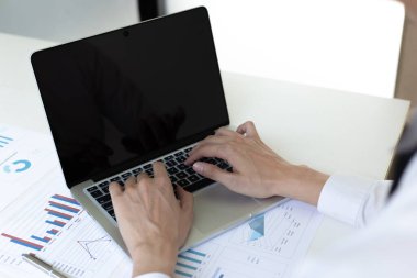 Finans işadamları, müşterileri, Muhasebe ve Vergi kavramlarının şirket vergilerini azaltmak için pazarlama stratejilerini ve emlak verilerini analiz etmek için dizüstü bilgisayar kullanıyorlar..