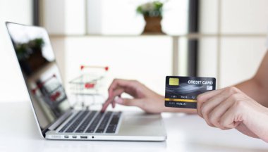 Erkekler internet üzerinden kredi kartı ödemelerini, teknoloji ve İnternet 'te rahatlığı, online alışveriş ve çevrimiçi bankacılık kavramını kullanarak çevrimiçi alışverişleri kaydetmek için dizüstü bilgisayar kullanıyorlar.