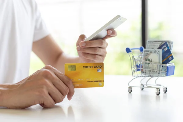 남성들은 신용카드 기술과 인터넷의 온라인 쇼핑과 개념을 이용하여 온라인 구매를 — 스톡 사진