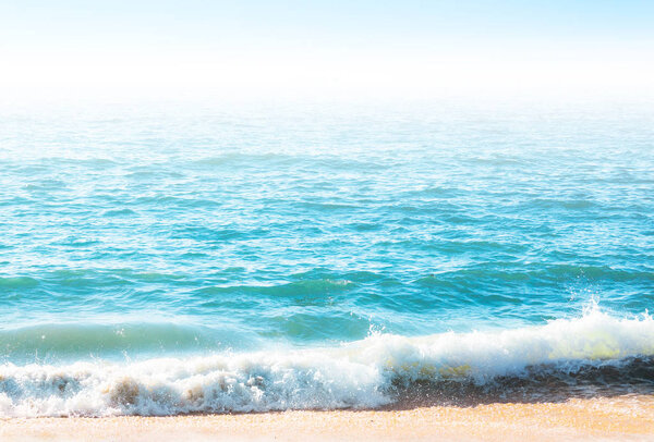 Seafoam on the coast with water surface on the background