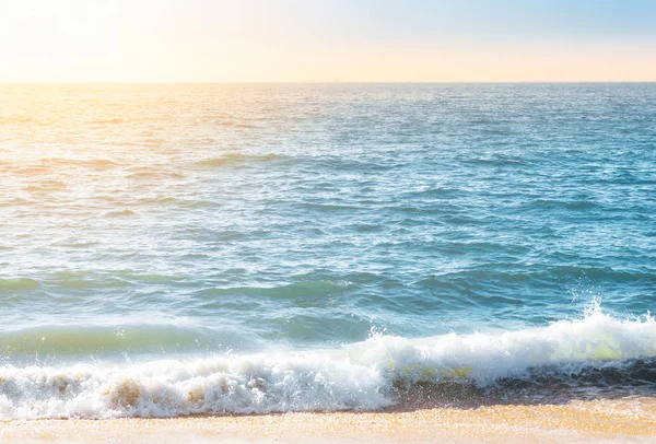 Морская пена на побережье с водной поверхностью на заднем плане — стоковое фото
