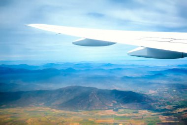 Uçak kanadı ile arka planda dağlar