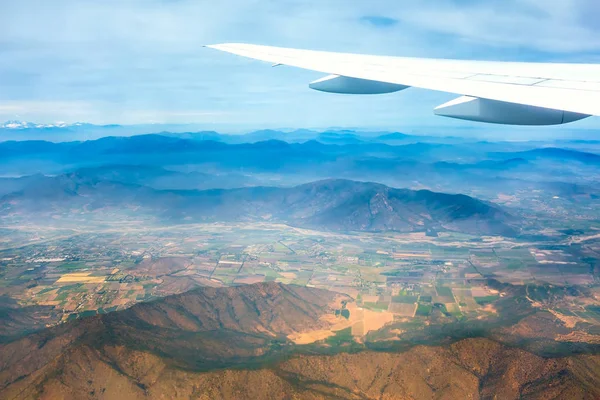 Uçak kanadı ile arka planda dağlar
