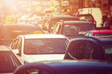 Gün batımında trafik sıkışıklığında arabalarla çevrili bir taksi.