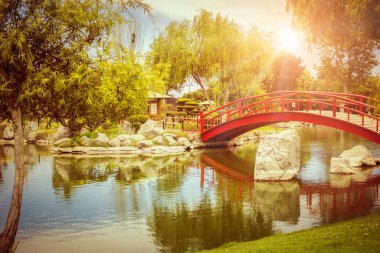 Şili, La Serena 'da gün batımında Japon bahçesinde gölün altında güzel kırmızı bir köprü.