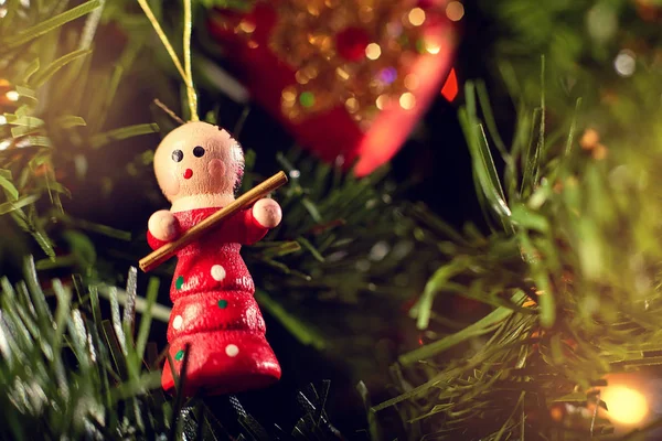 Ağaçta asılı oyuncak bebek yeşil iğneler ve Noel oyuncakları kırmızı kalp ve renkli bokeh