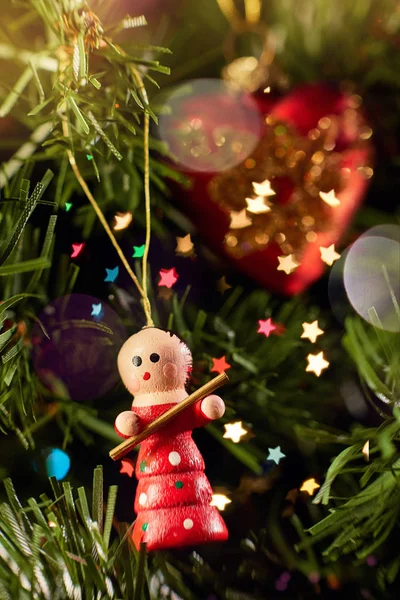 Ağaçta asılı oyuncak bebek yeşil iğneler ve Noel oyuncakları kırmızı kalp ve renkli bokeh