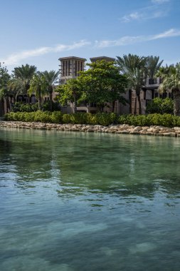 Güneşli bir günde zümrüt suyla kanal boyunca yürüyün.