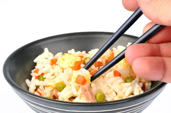 Eating Cantonese rice with chopsticks in closeup on white background