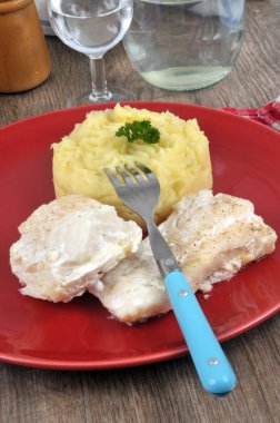 Kapalı tabakta servis edilen patates püresiyle morina balığı.