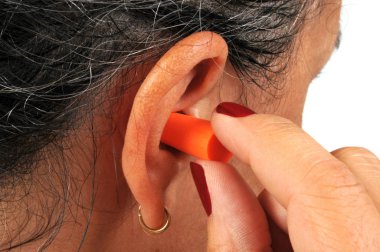 Kulak tıkacı takarak duyma yetisini koruyan kadın. 