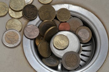 Lavabonun giderine yakın planda Euro sikkeleri 