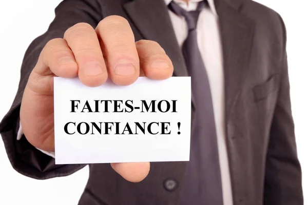 フランス語で書かれたカードを持っている匿名のビジネスマンは私を信頼する — ストック写真