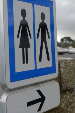 Road sign indicating public toilets for women and men