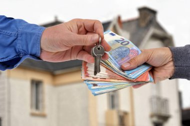 Banknotlar için birkaç anahtar değiş tokuşu. Bir evin önünde.