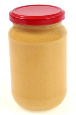 Beyaz arkaplanda bir kavanoz hardal yakın plan