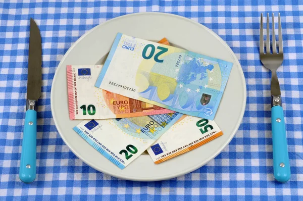 Damalı masa örtüsü ve çatal bıçak takımının üzerinde bir tabak banknotla nafaka kavramı