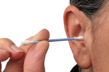 Beyaz bir arka planda kulaklarını pamukla temizleyen bir kadın.