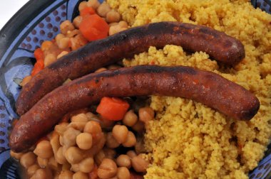 Sebzeli kuskus ve merguez yakın planda.