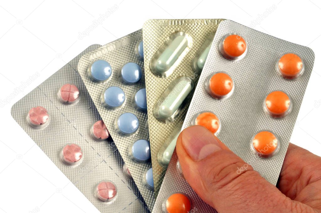 Blister pack of drugs in hand close-up on white background 