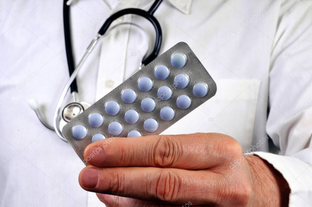 Doctor holding a blister pack of drugs in hand close-up 