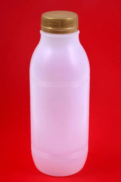 Botella Plástico Cerca Sobre Fondo Rojo —  Fotos de Stock