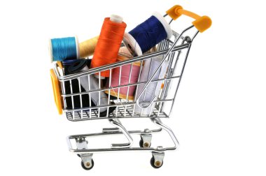 Supermarket cart with spools of thread close up on white background