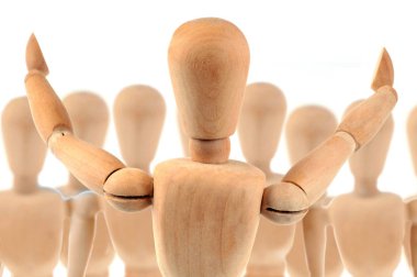 Wooden mannequin making a speech in front of a crowd of wooden mannequins clipart
