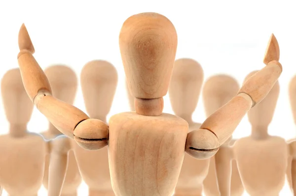 Wooden mannequin making a speech in front of a crowd of wooden mannequins