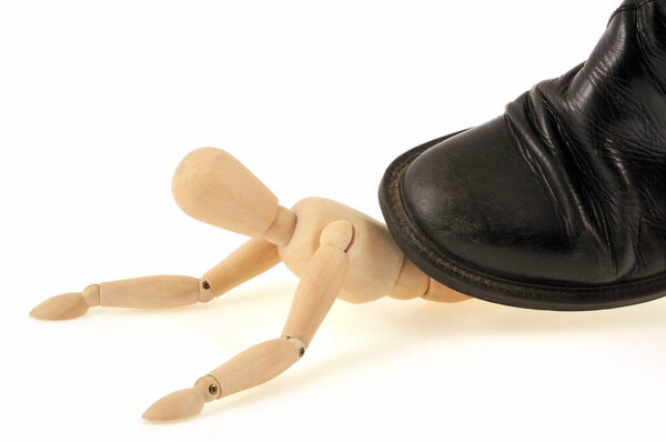 Деревянный манекен раздавлен обувью крупным планом на белом фоне

