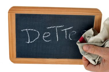 Erase the word debt written on a school slate with a chalk