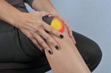 Knee pain close up on gray background  clipart