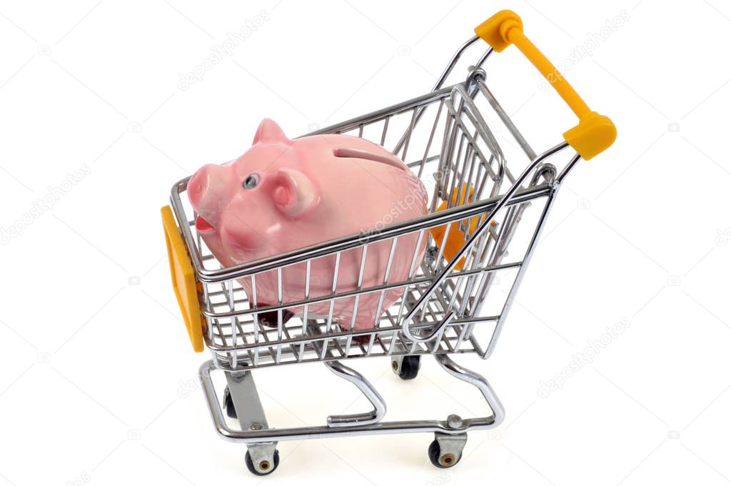 Piggy bank in a supermarket cart close up on white background