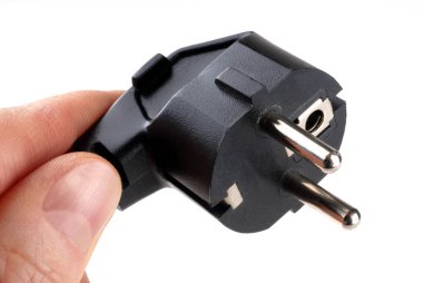 Siyah elektrik prizi beyaz arkaplanda el ele tutuşur. 