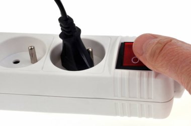 Beyaz arka planda yakın plan düğmesi olan çoklu soket uzatma kablosu