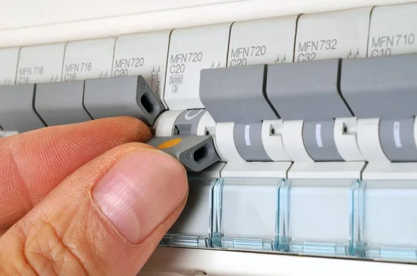 Hand changing fuse of electrical panel in close up