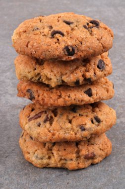 Gri arka planda çikolata parçacıklı ev yapımı kurabiyeler.