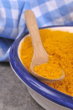 Tahta kaşık, toz zerdeçal tabağında. Yaklaş.