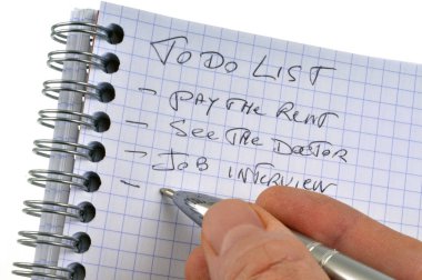 Beyaz arkaplana yakın plan sarmal bir not defterine yazılmış yapılacak işler listesi 