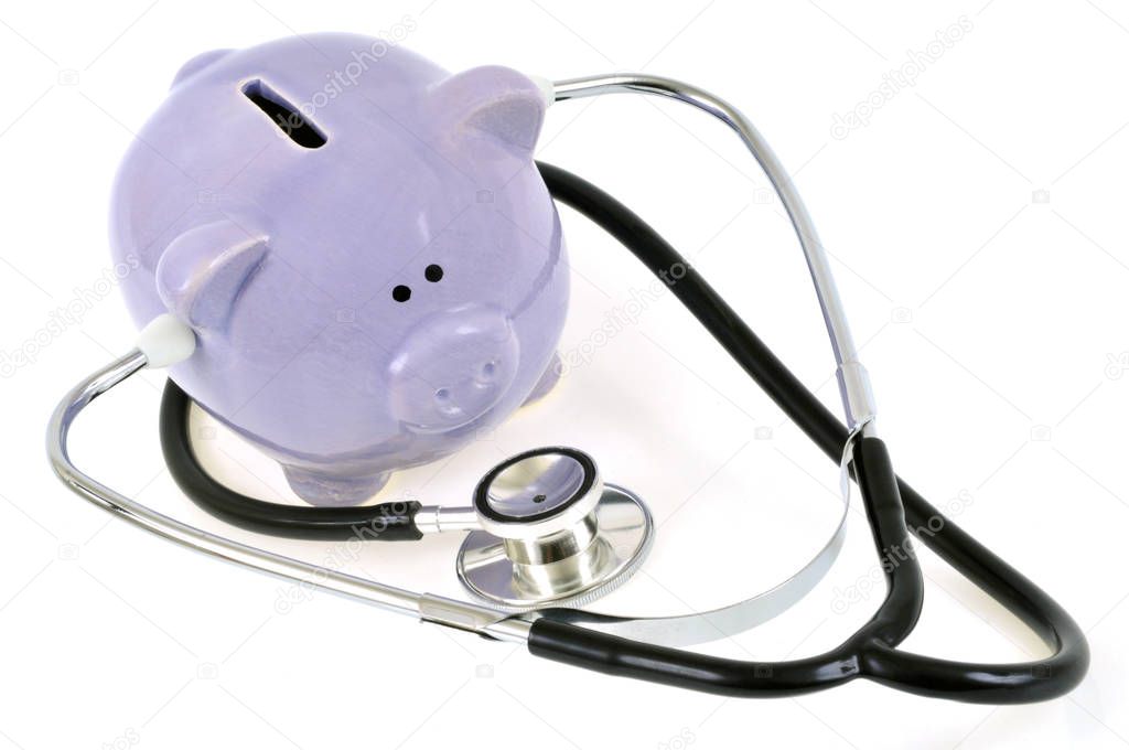 Piggy bank with stethoscope close up on white background 