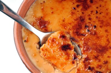 Beyaz bir arka planda ramekin içinde ev yapımı creme brulee. 