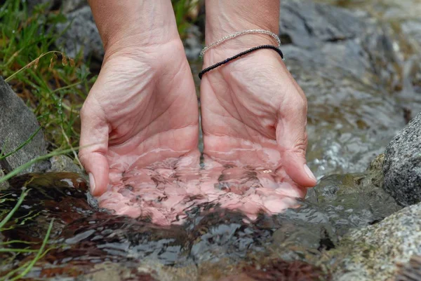 Hands in a mountain stream close-up