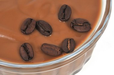 Beyaz arka planda kavrulmuş kahve çekirdekli kremalı ramekin.